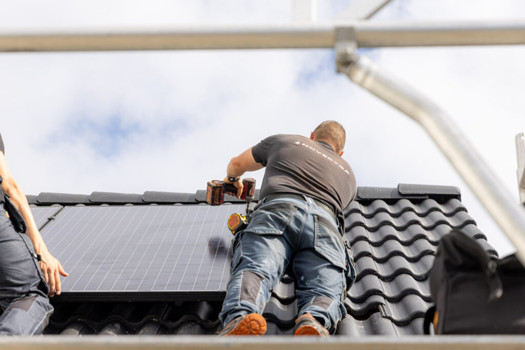 Novectra technician installing a solar panel on a residential roof